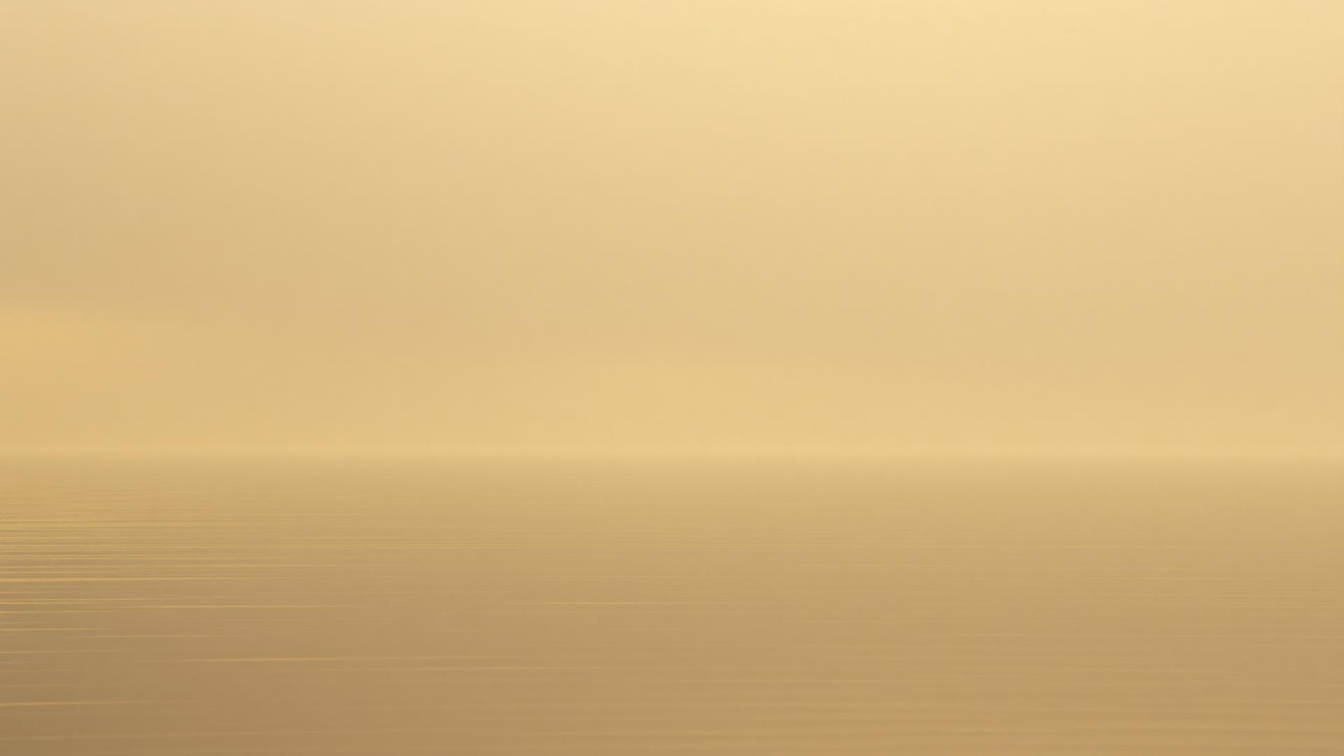 Dawn light spreading across still water